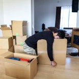 Article thumbnail: A tired Japanese man is sleeping on a cardboard box in his new house.