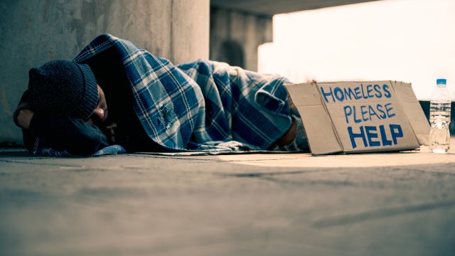 Article thumbnail: Homeless man slept on a piece of cardboard with an old blanket.