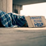 Article thumbnail: Homeless man slept on a piece of cardboard with an old blanket.