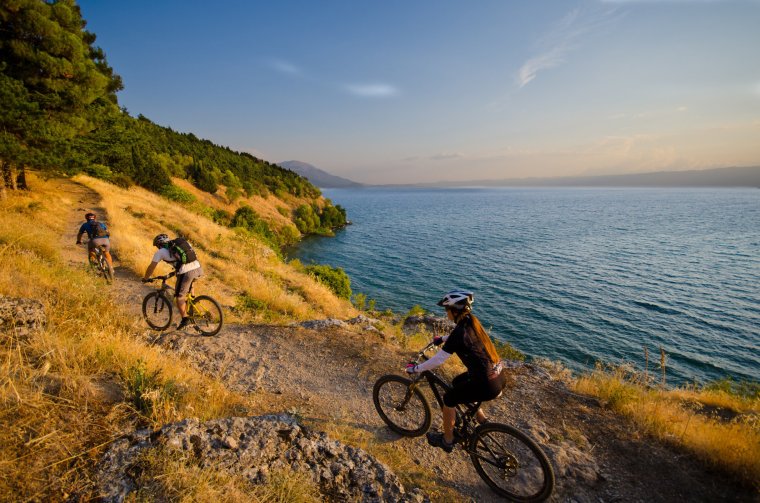 Three mountain bikers on a singletrack above lake Ohrid in Macedonia
