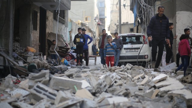 KHAN YUNIS, GAZA - DECEMBER 24: People, including children, are seen amid damaged structures after Israeli attacks in Khan Yunis, Gaza on December 24, 2023. (Photo by Ahmed Zaqout/Anadolu via Getty Images)